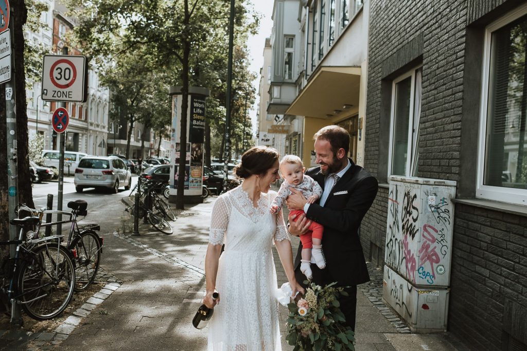 Urbane Hochzeit in Düsseldorf Fliegern Brautpaar läuft über die Ackerstrasse