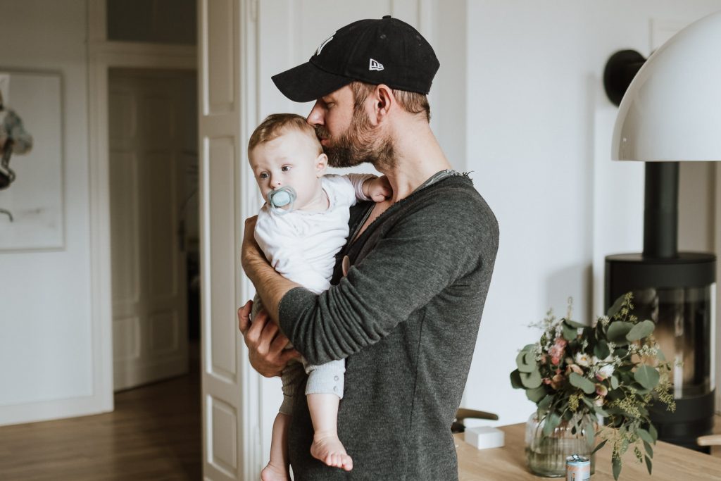 Vater küsst kleine Tochter auf die Schläfe