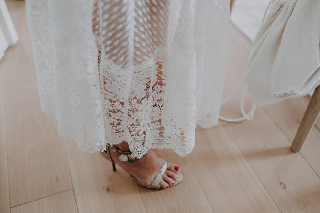 Spitzenkleid Details des Brautkleides und der Brautschuhe