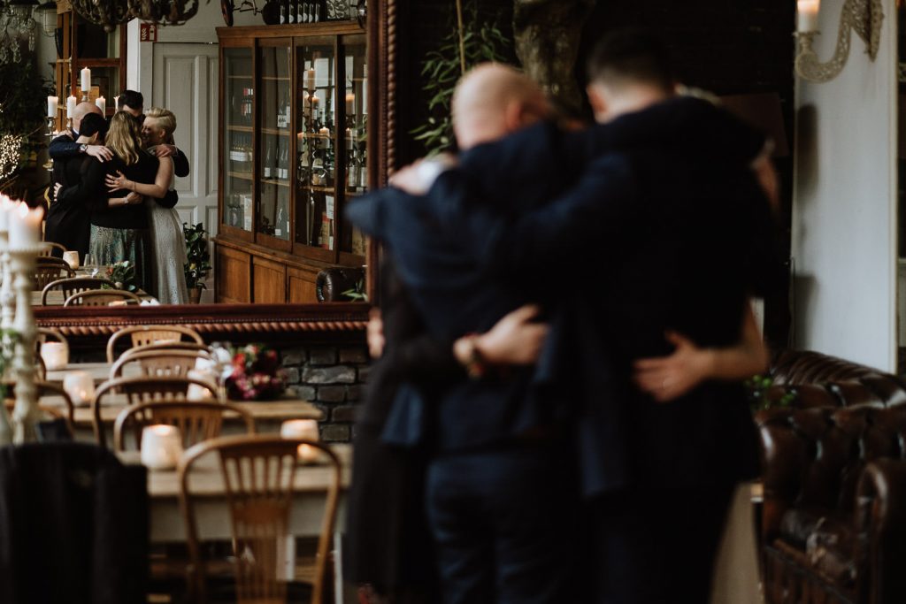 Brautpaar umarmt die Trauzeugen und die freie Rednerin vor einem Spiegel