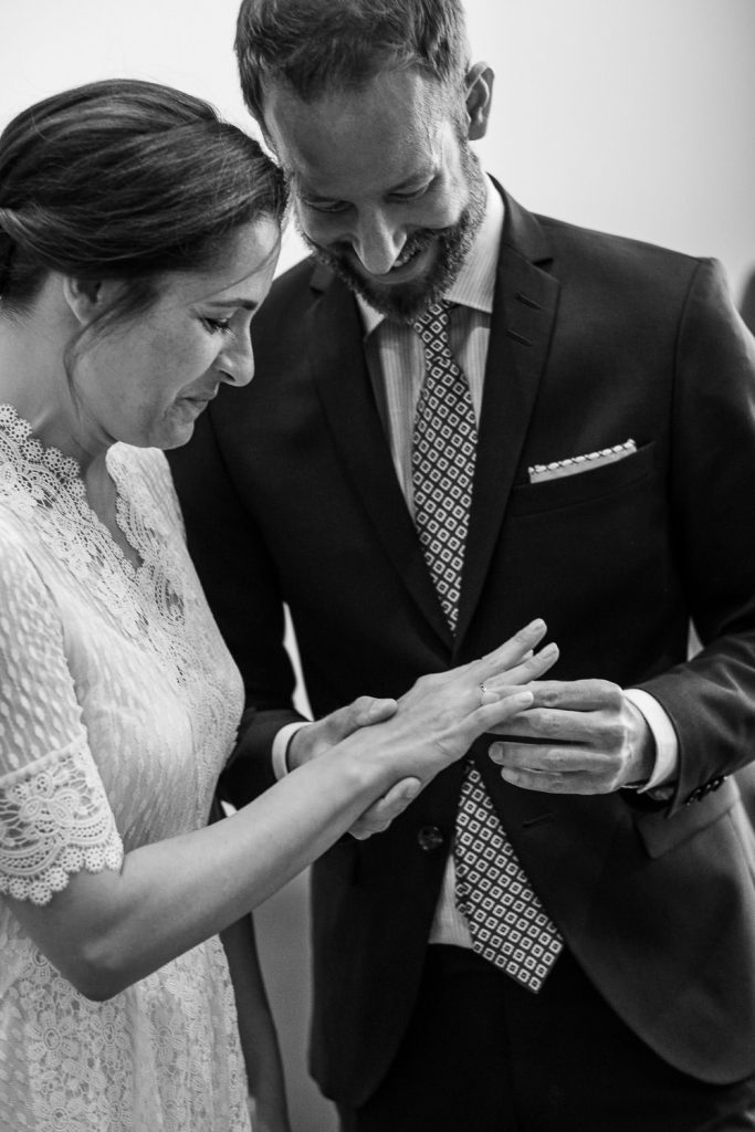 Bräutigam steckt der Braut den Ring im Standesamt an