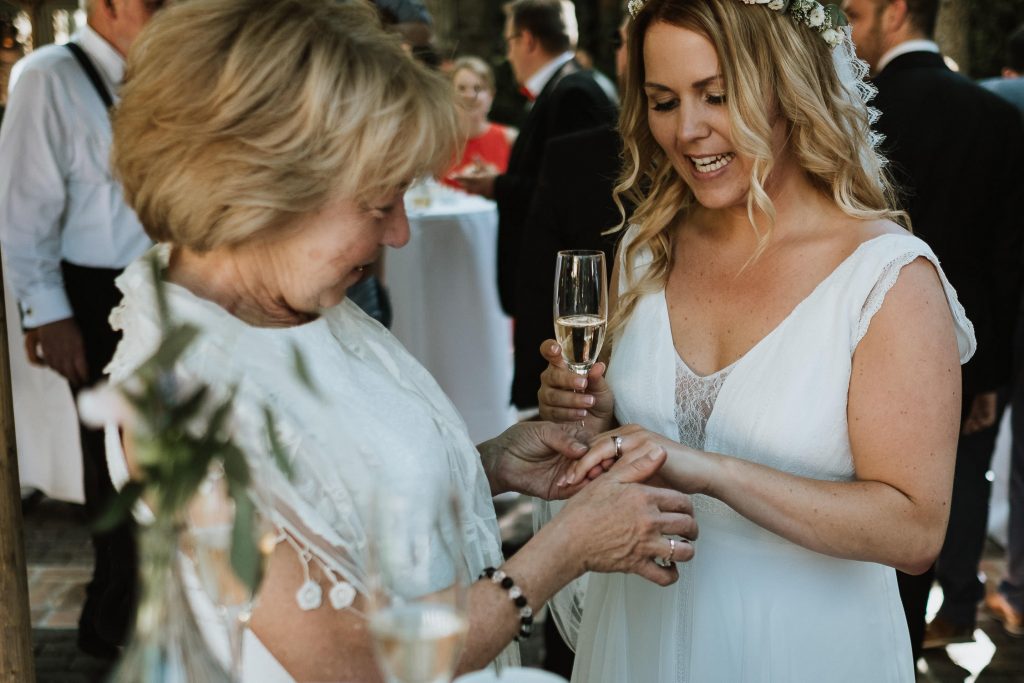 Braut zeigt ihren Ehering ihrer Mutter