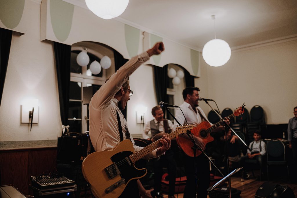 Bräutigam spielt mit seiner Band auf seiner Hochzeit für die Gäste