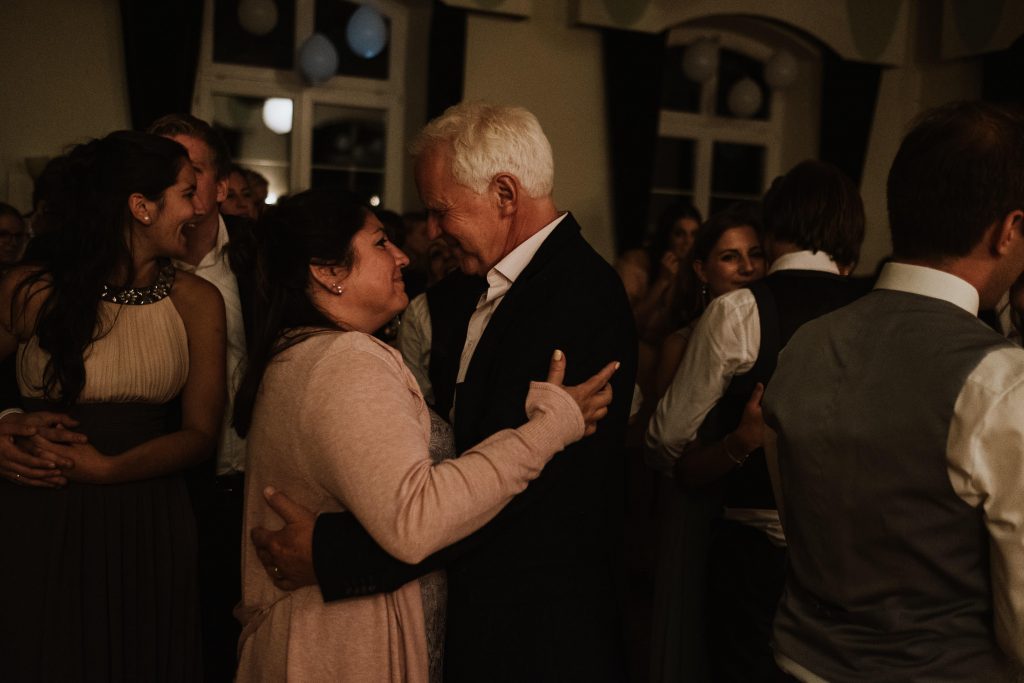 Gäste einer Hochzeitsgesellschaft tanzen liebevoll miteinander