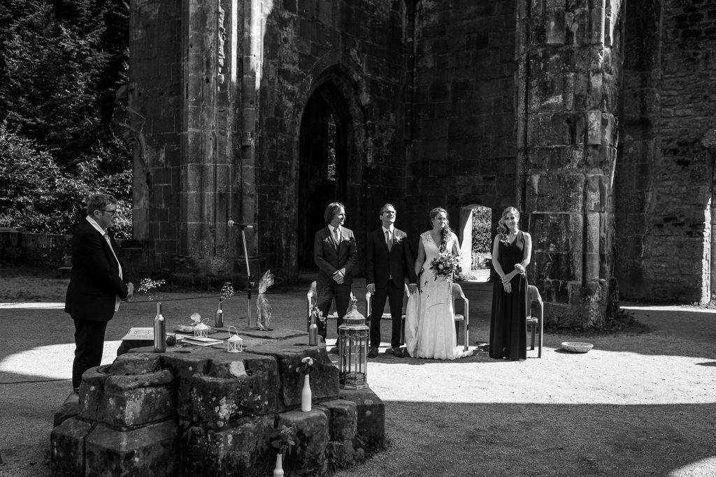 Brautpaar und Trauzeugen sitzen während der individuellen Trauung in der Klosterruine Allerheiligen