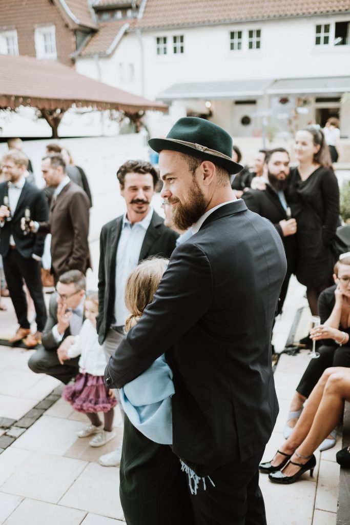 Gast einer Hochzeitsgesellschaft mit Hut und Anzug