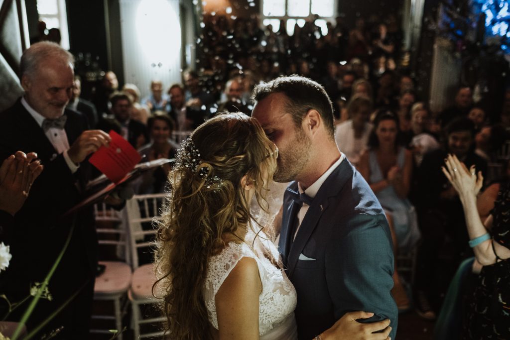Braut und Bräutigam küssen sich während der freien Trauung in der Villa Rheinperle in Duisburg