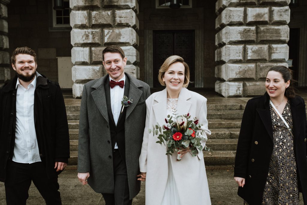 Brautpaar mit zwei Trauung vor dem Eingang des Standesamt Mühlheim